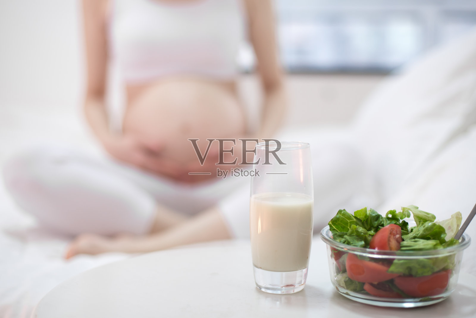 健康的营养和怀孕。孕妇的肚子和蔬菜沙拉照片摄影图片