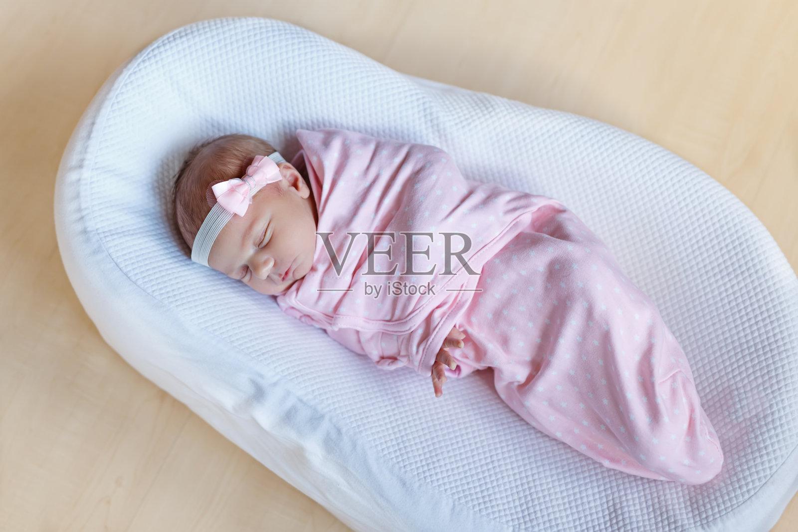 一个星期大的新生女婴裹着毯子睡觉照片摄影图片