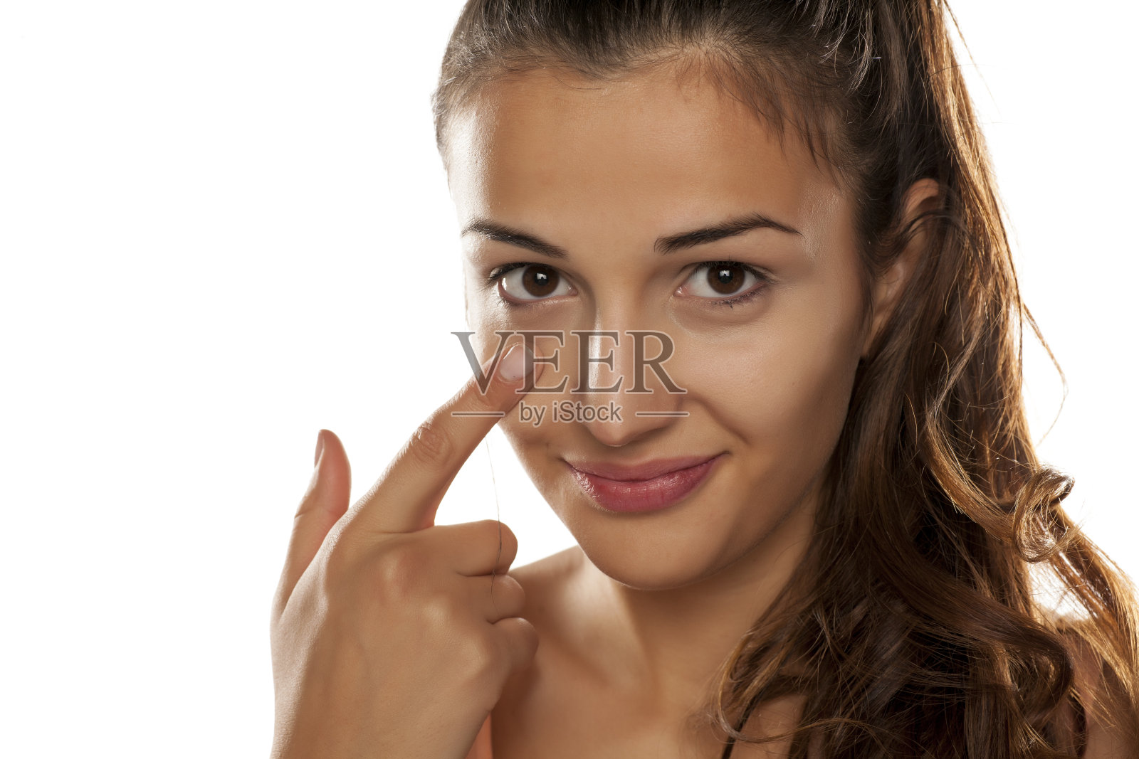 年轻女子在眼圈上涂遮瑕膏照片摄影图片
