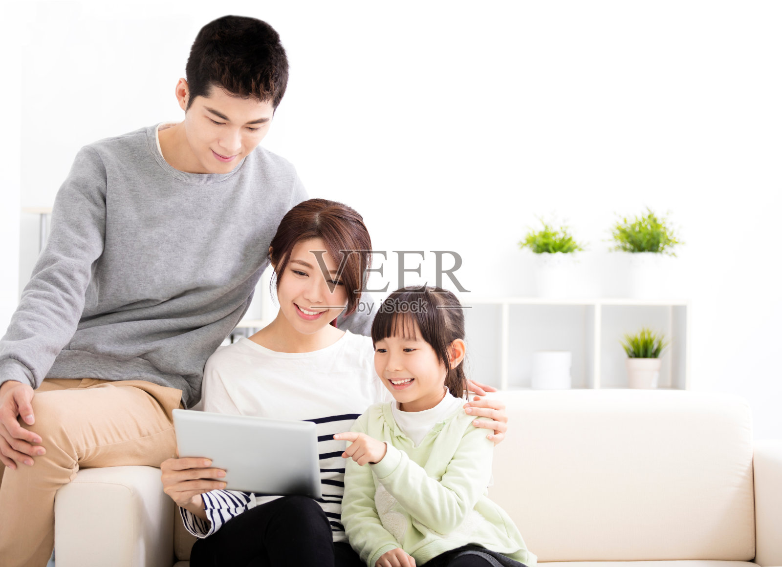 快乐有吸引力的年轻家庭看平板电脑照片摄影图片