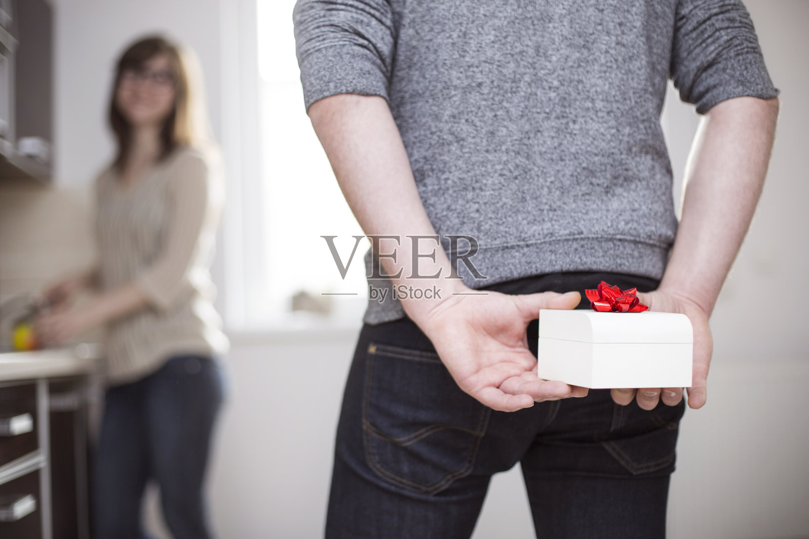 一个男人站着，背后拿着白色的礼品盒照片摄影图片