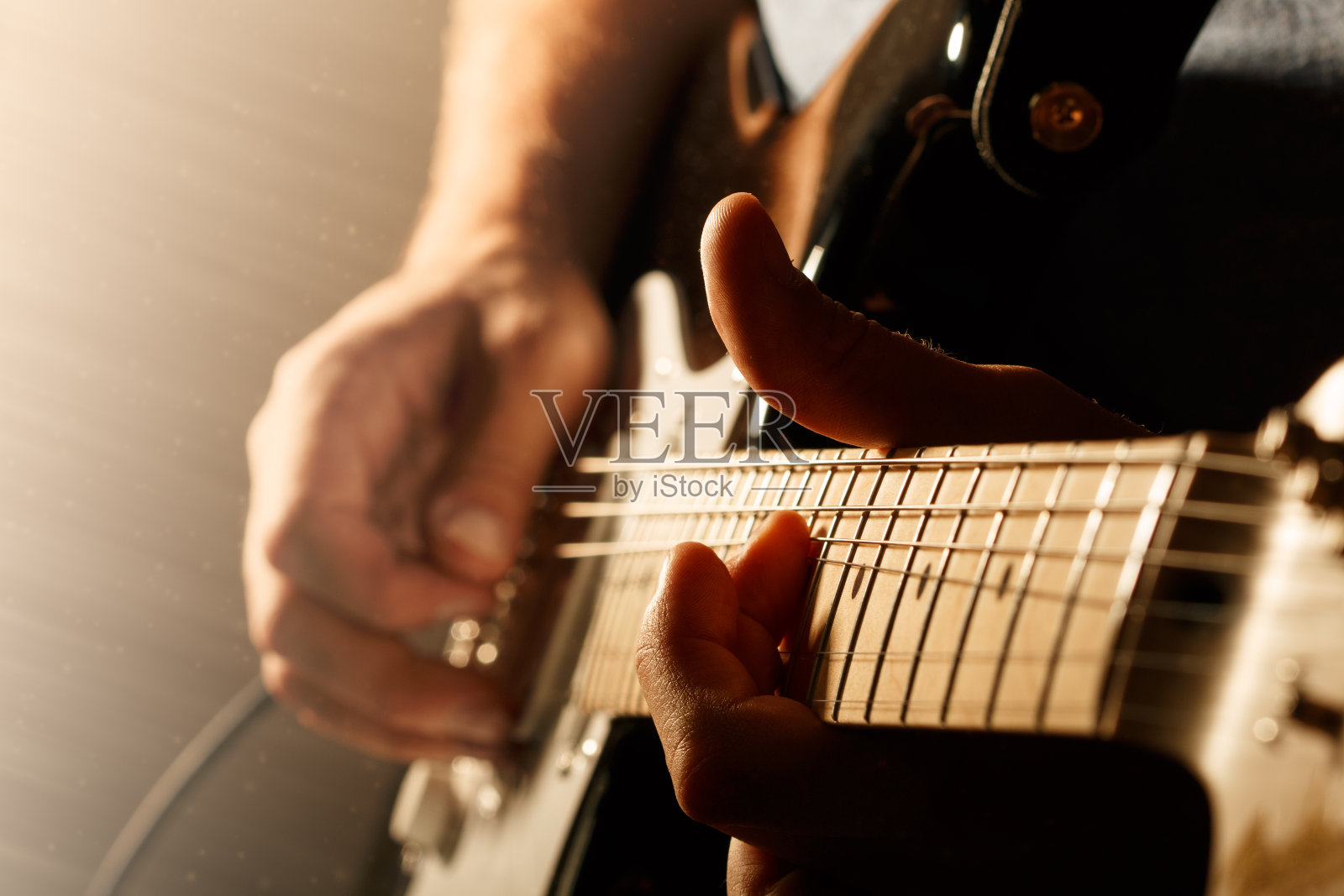 男子的手指弹奏电吉他的特写照片摄影图片