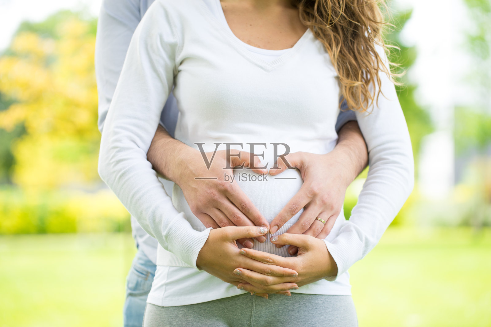 快乐和年轻的怀孕夫妇在公园夏天照片摄影图片