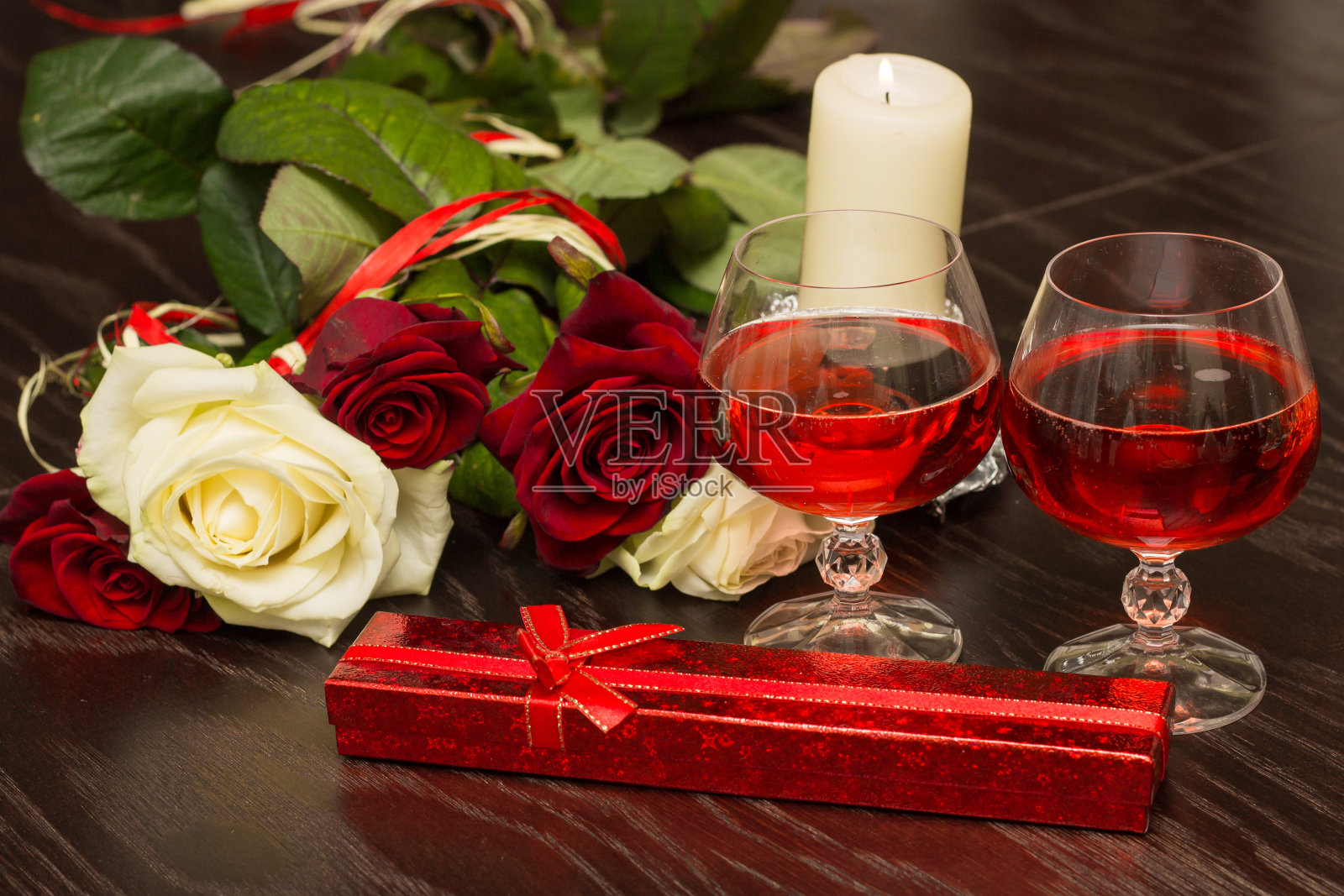 玫瑰，几杯葡萄酒和一盒珠宝在烛光下照片摄影图片