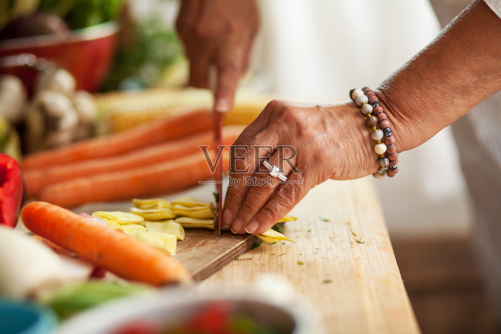 年长妇女准备蔬菜。照片摄影图片