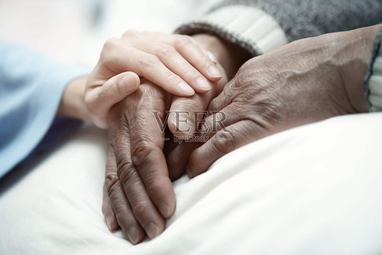 在诊所里，女人的手抚摸着老男人照片摄影图片