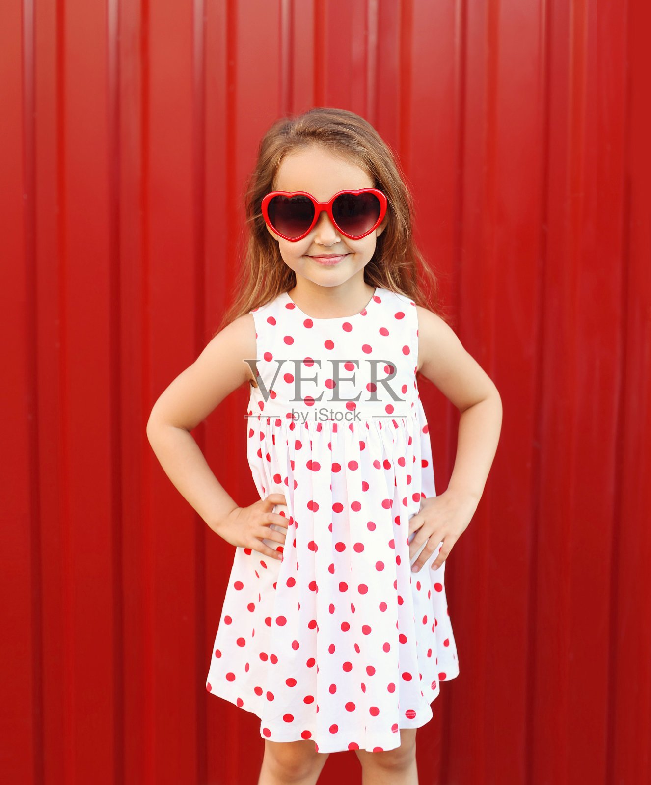 美丽微笑的小女孩孩子穿着连衣裙和红色的太阳镜照片摄影图片