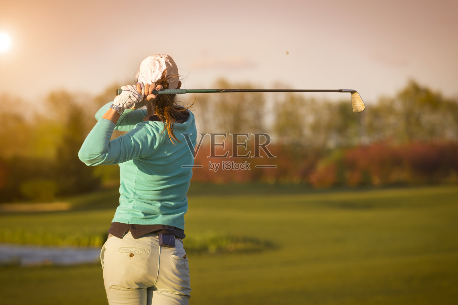 女子高尔夫球手击球。照片摄影图片
