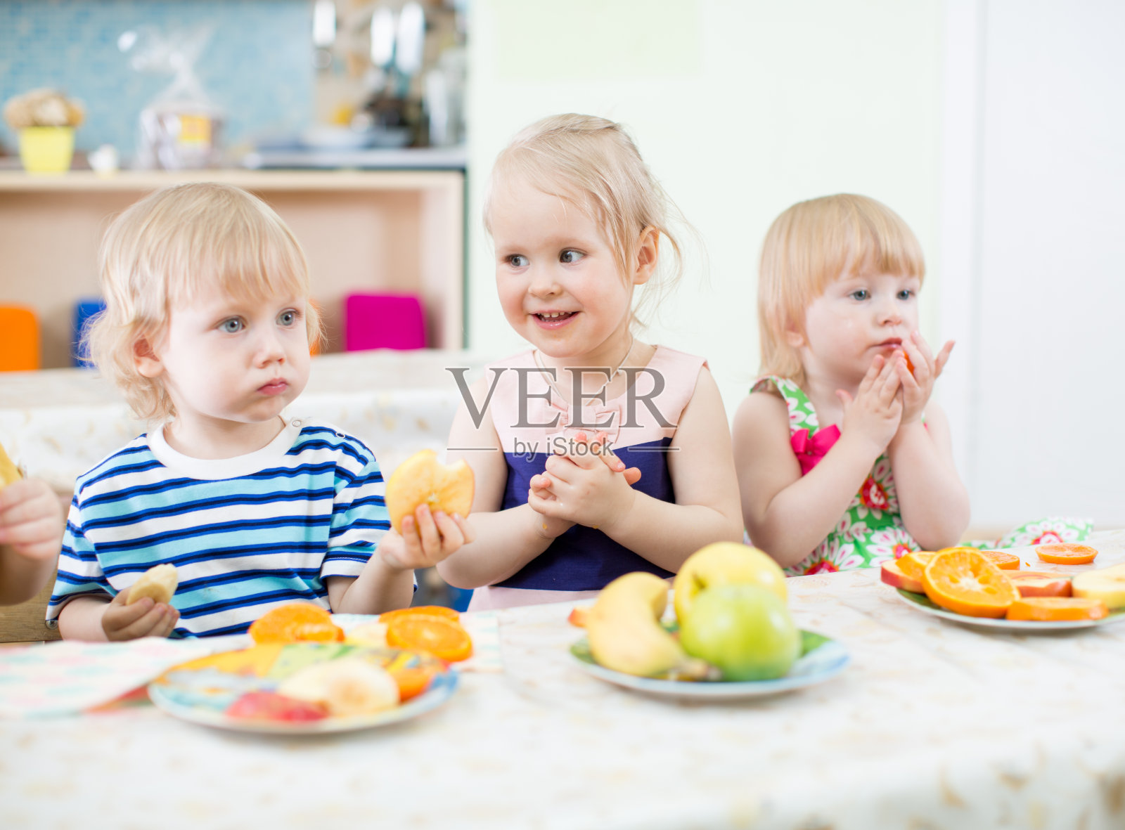 孩子们在幼儿园餐厅吃水果照片摄影图片