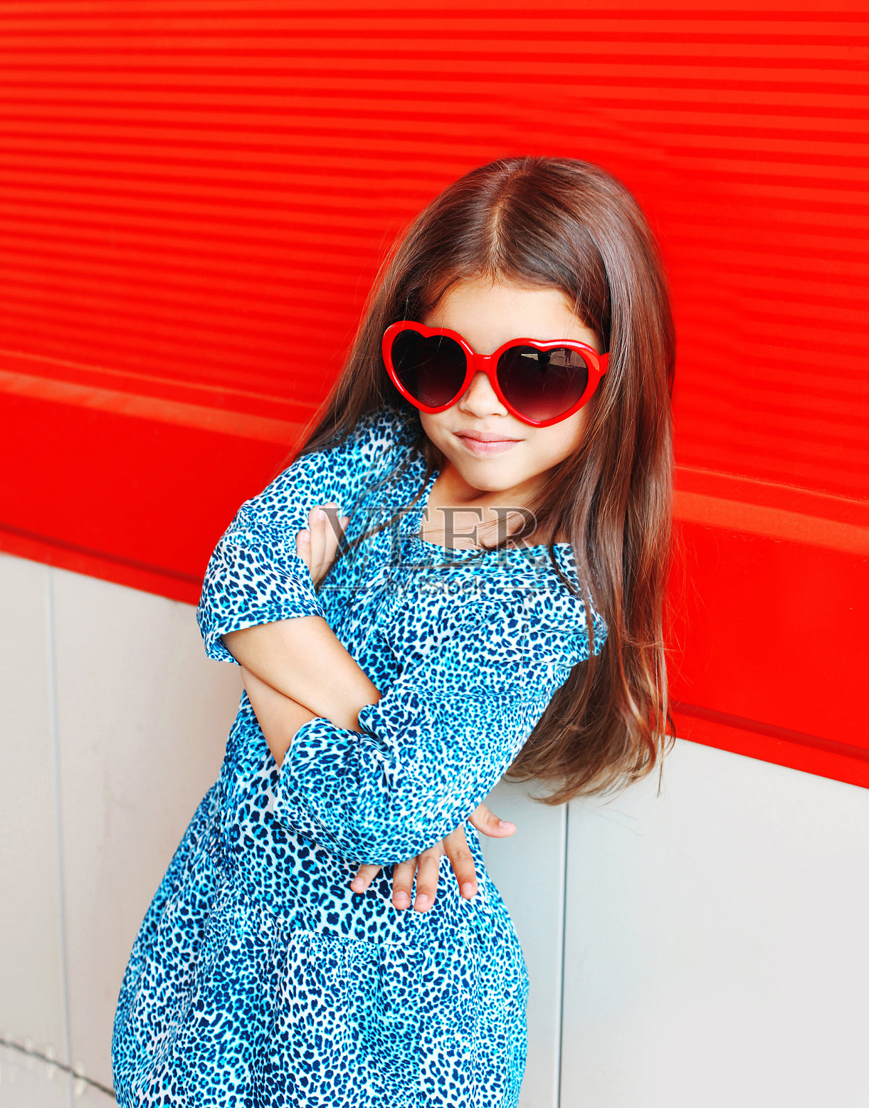 漂亮的小女孩穿着豹纹衣服，戴着红色太阳镜照片摄影图片
