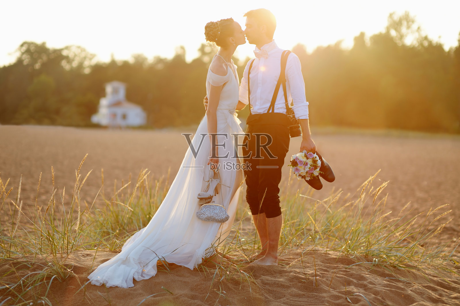 日落时分，新郎和新娘在海滩上照片摄影图片