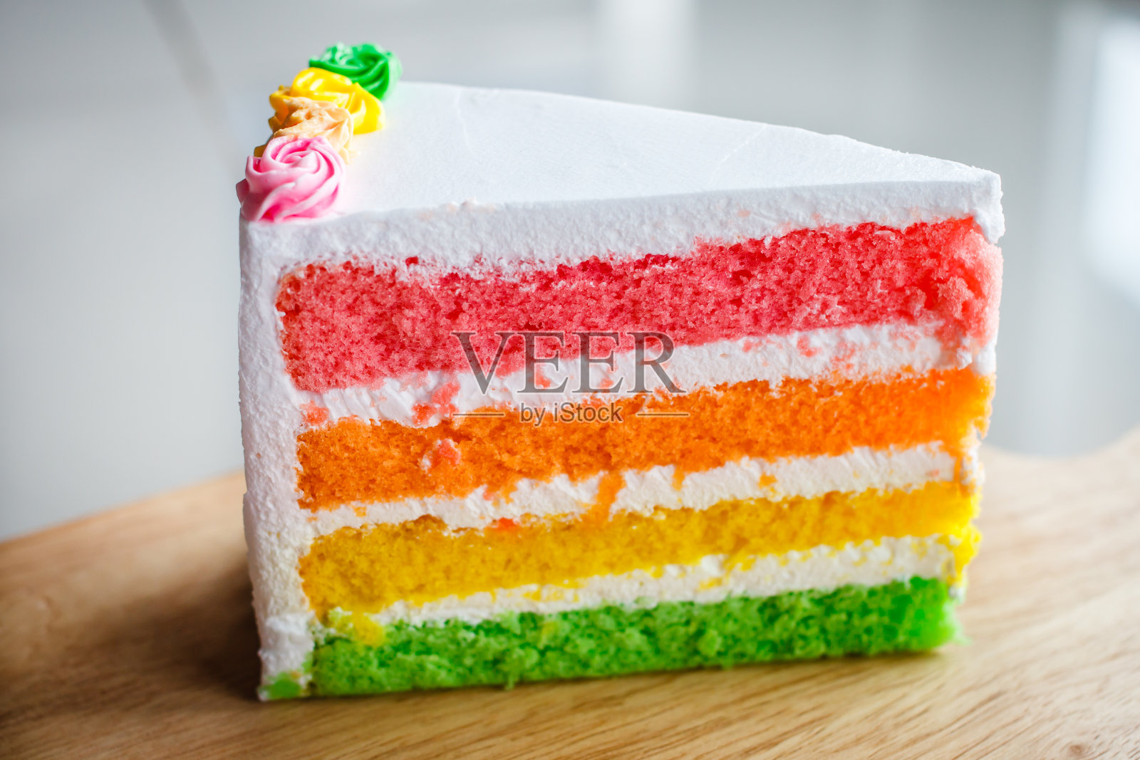 美味的彩虹蛋糕在木板上。照片摄影图片