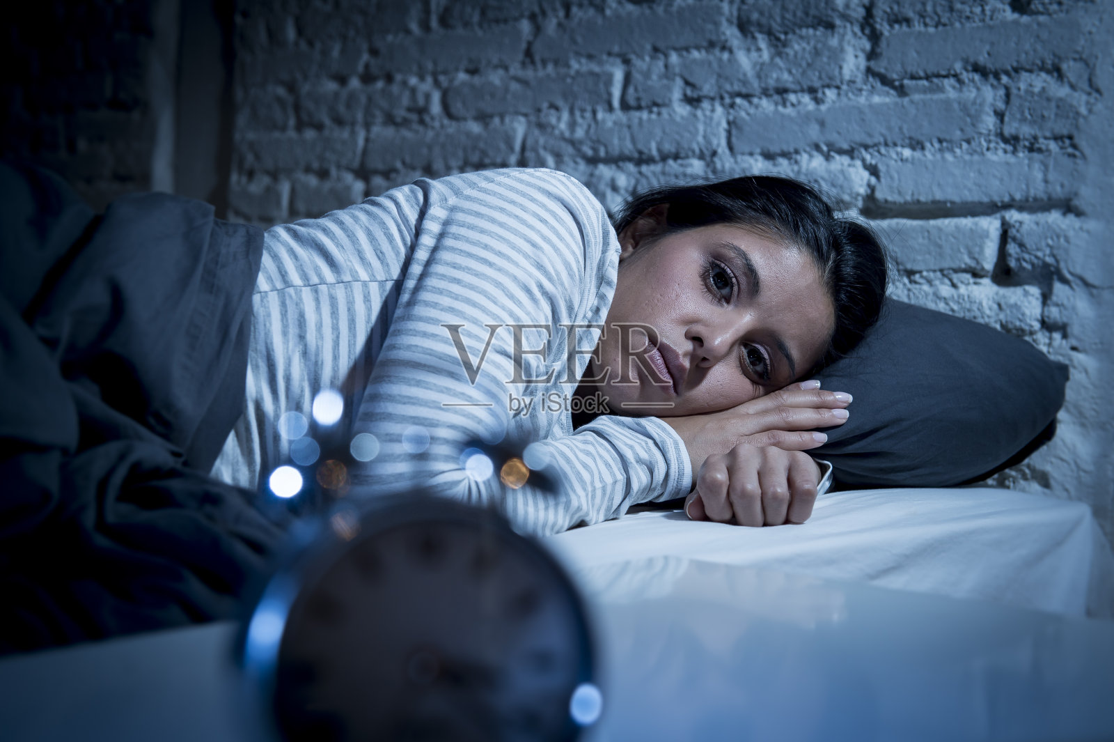 女人深夜躺在床上想睡觉却失眠照片摄影图片