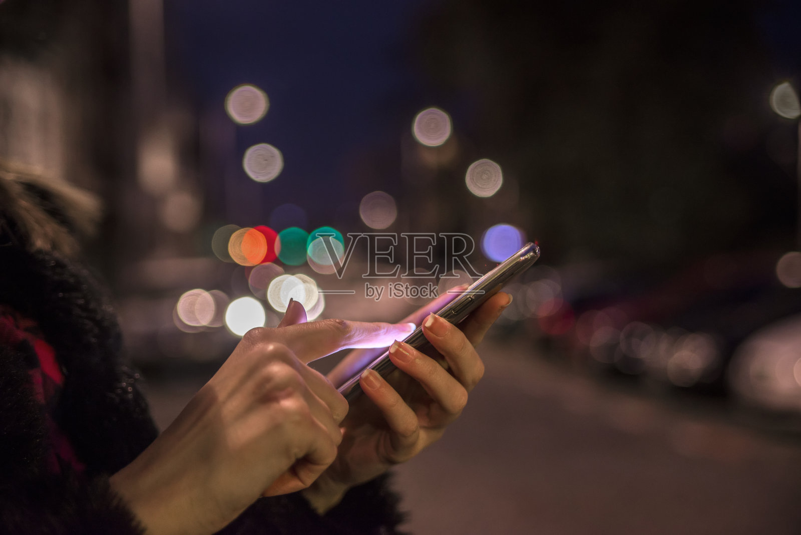 女人用手机，城市天际线夜光背景照片摄影图片