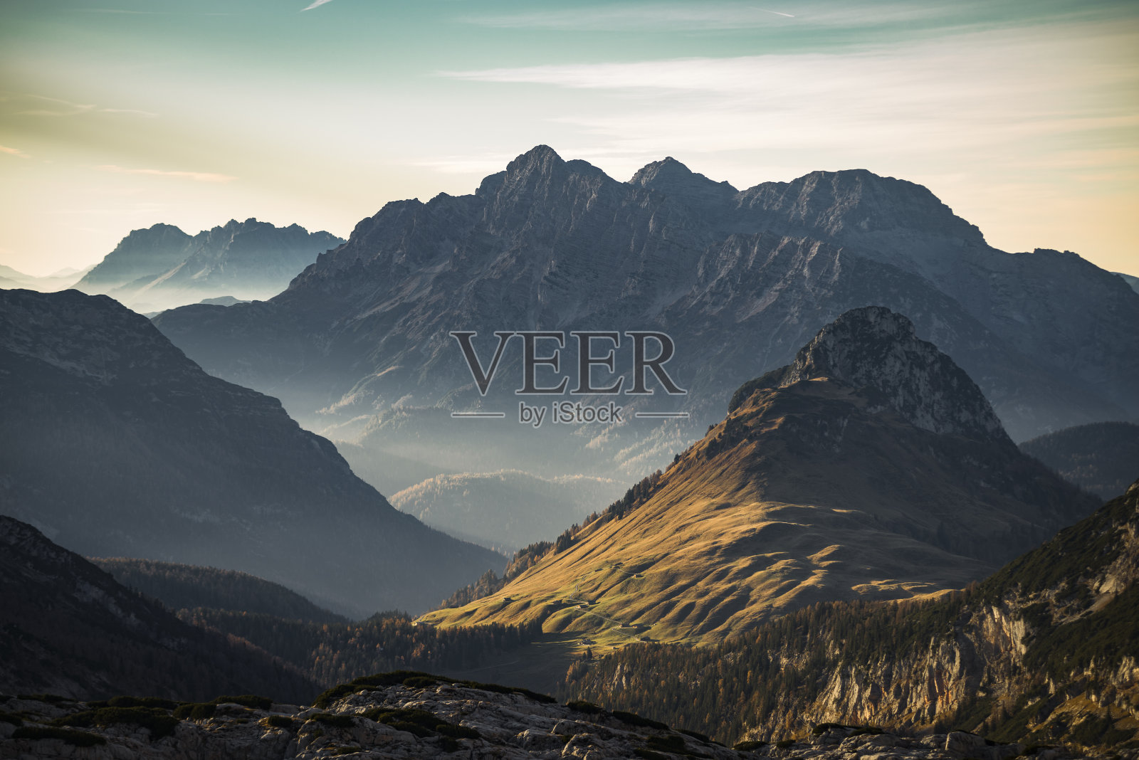 奥地利高山牧场和山脉上的晚秋日落照片摄影图片