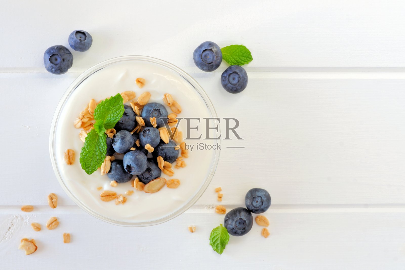 酸奶配蓝莓，格兰诺拉麦片，白木上面的景色照片摄影图片