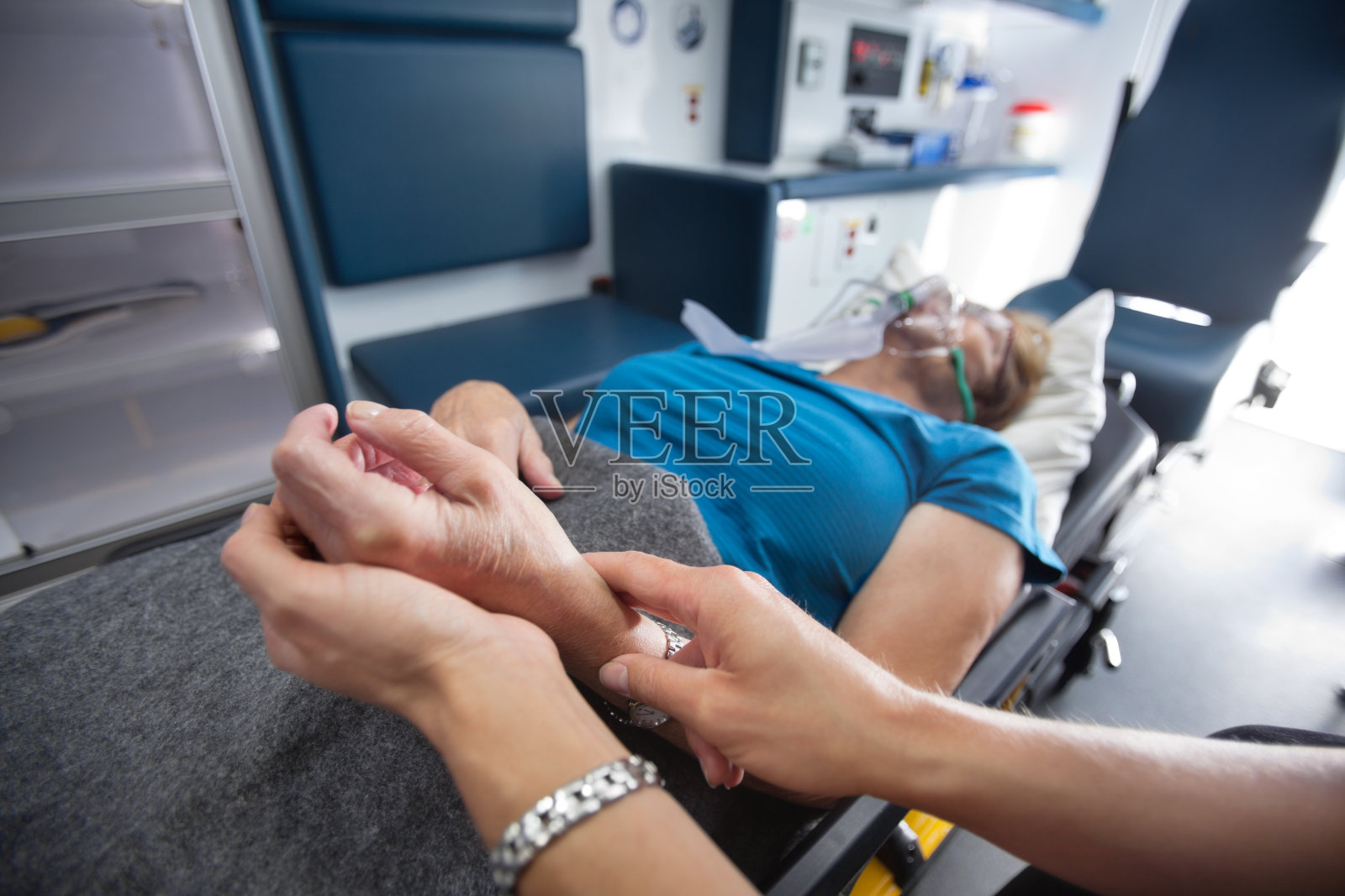 医护人员在救护车上测量一位妇女的脉搏照片摄影图片