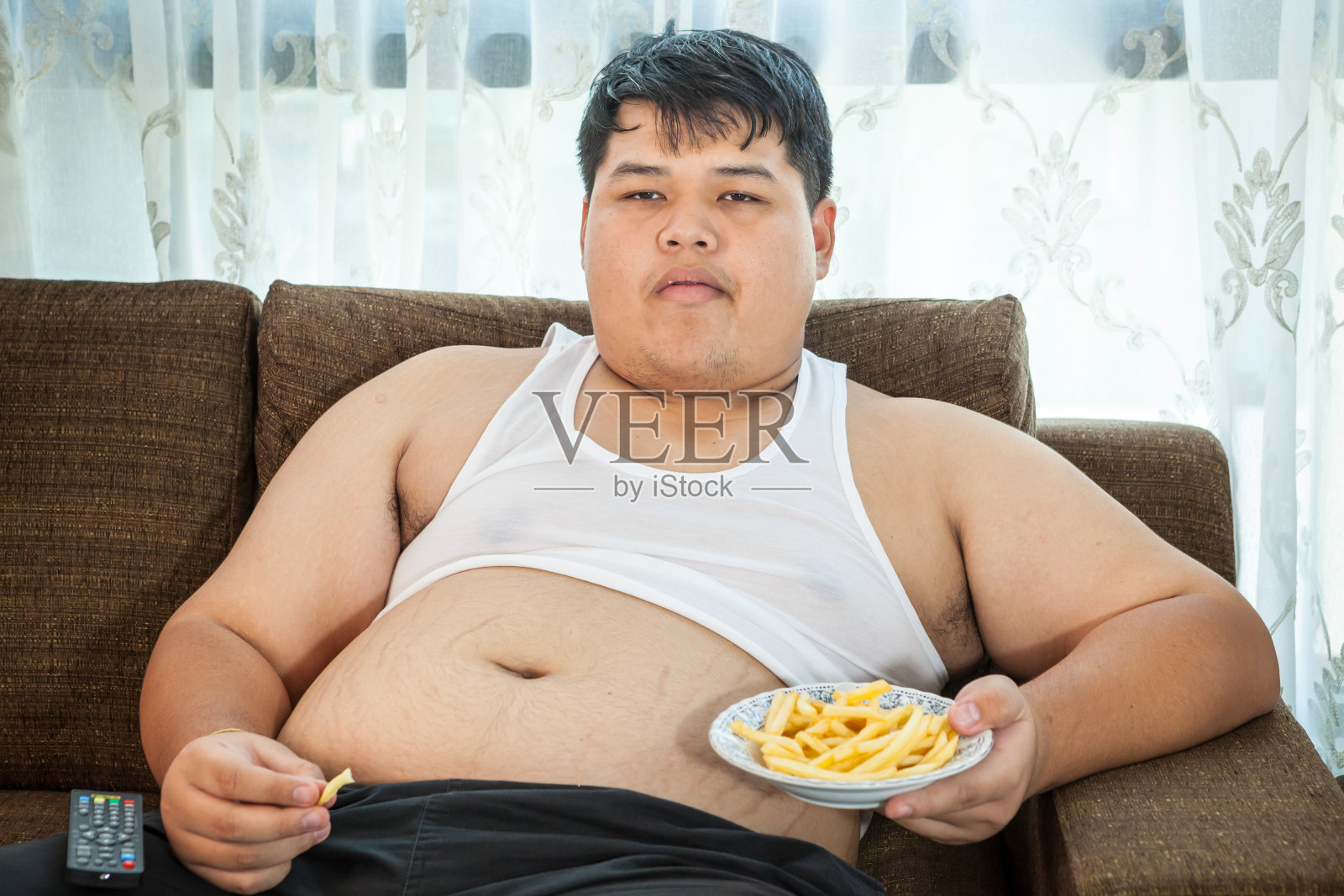 懒惰超重男性坐着吃快餐照片摄影图片