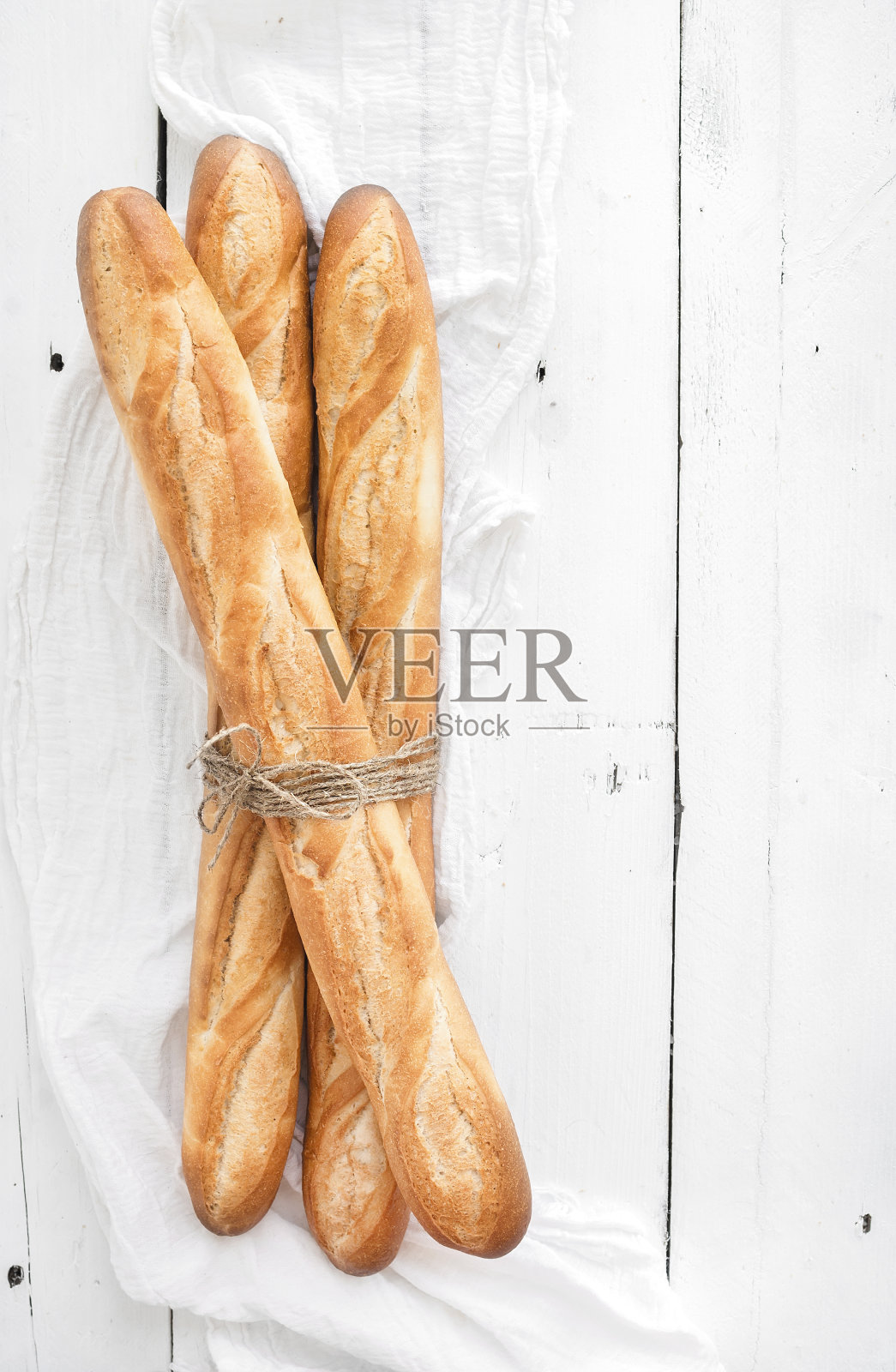 白木桌上刚烤好的法式长棍面包。俯视图照片摄影图片