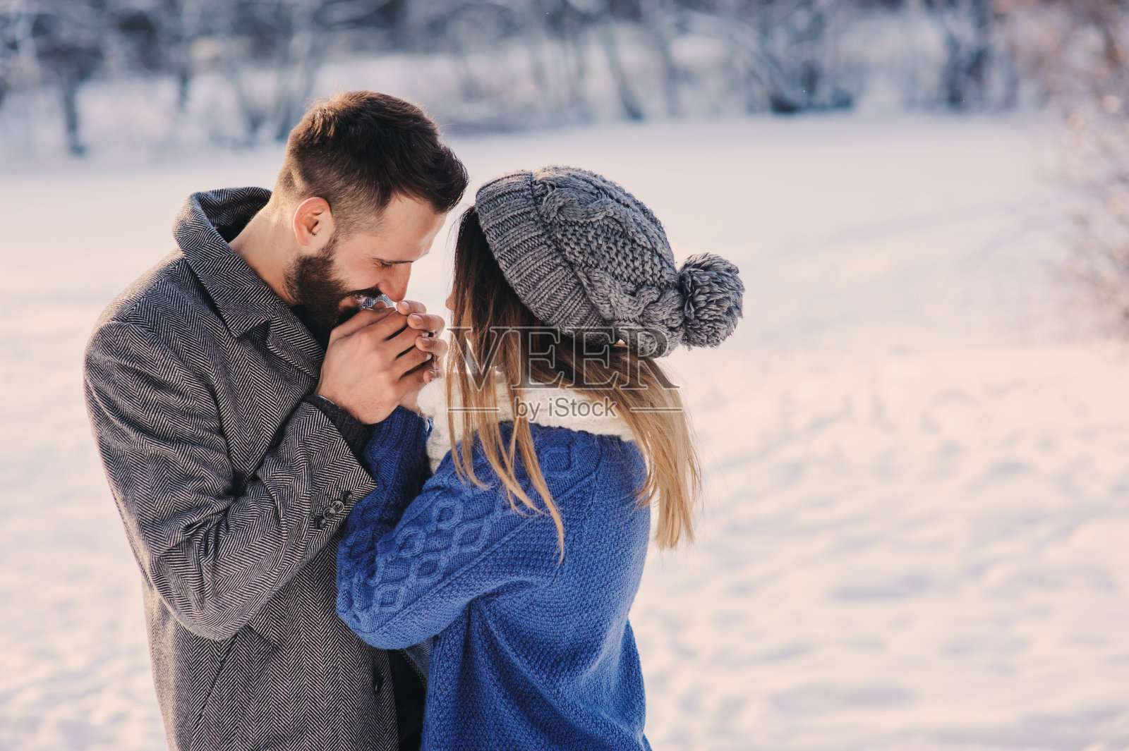 幸福的情侣漫步在白雪覆盖的冬日森林里照片摄影图片