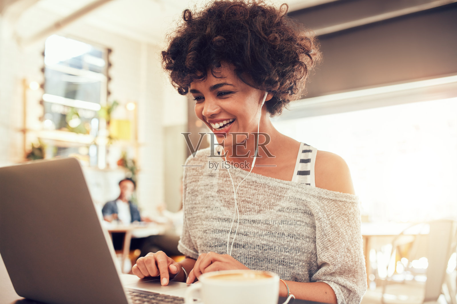 快乐的女人在咖啡馆使用笔记本电脑照片摄影图片