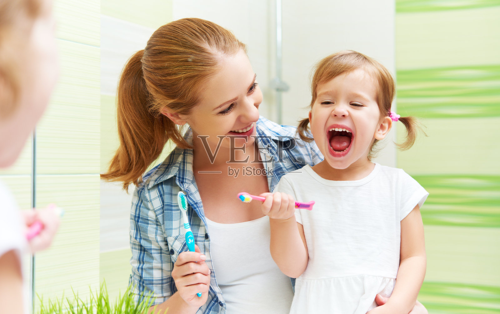 幸福的家庭，母子俩用牙刷清洁牙齿照片摄影图片