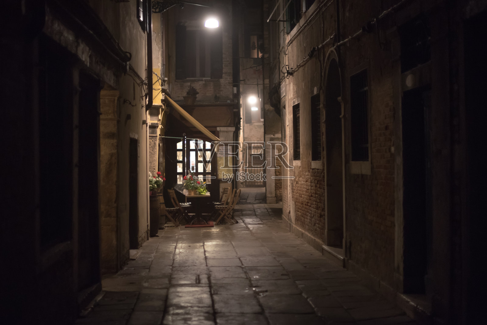 晚上在威尼斯小巷里的一家舒适的餐厅照片摄影图片