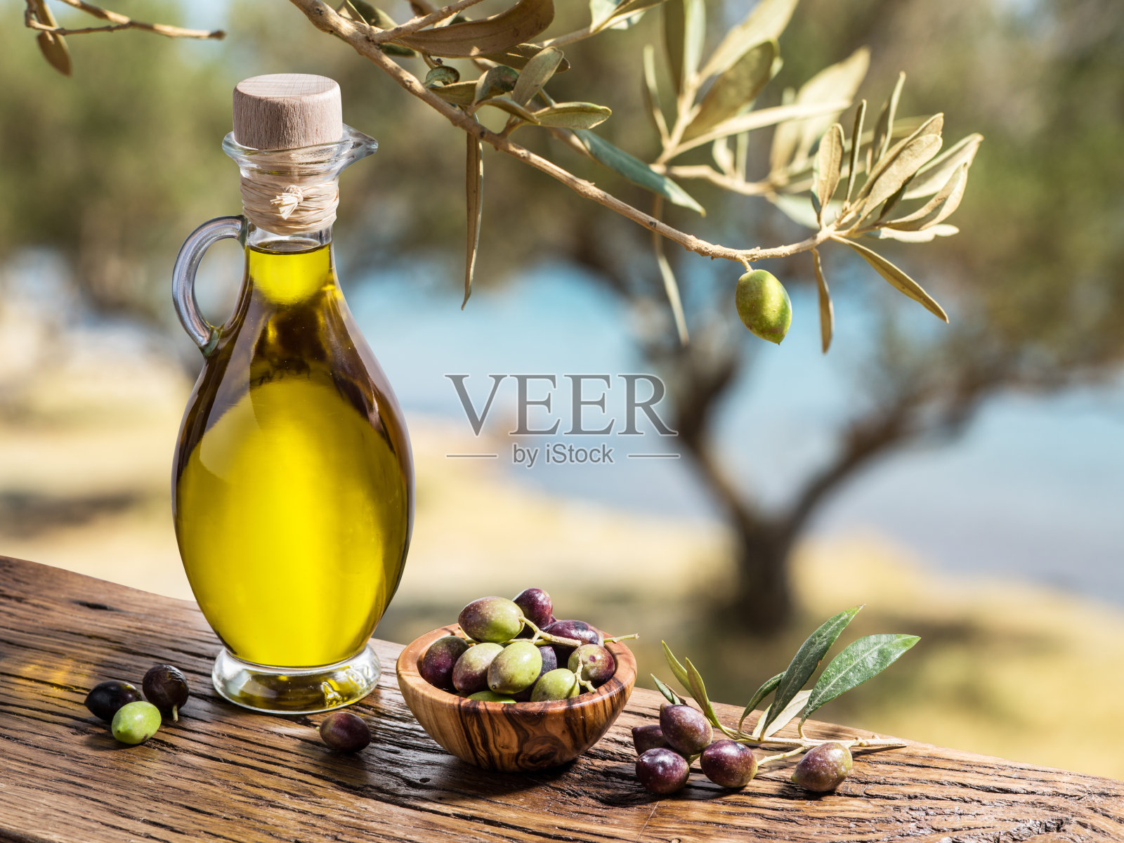 橄榄油和浆果在木桌上。照片摄影图片