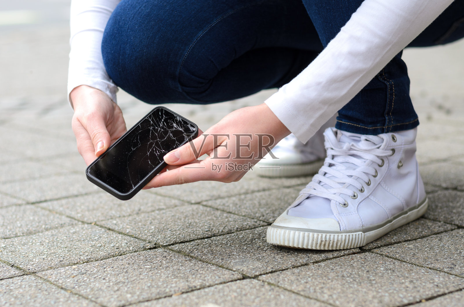 跪在街上捡破手机的人照片摄影图片