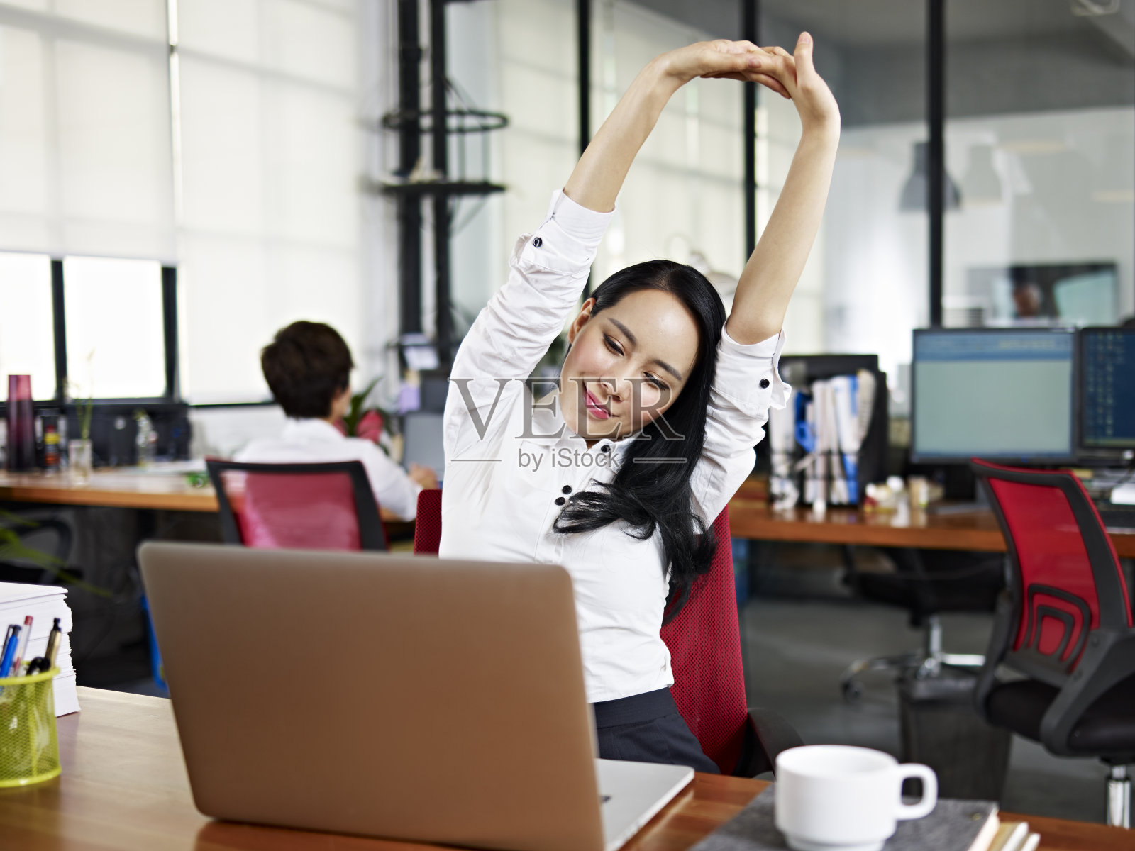 亚洲商业女性在办公室伸展手臂照片摄影图片
