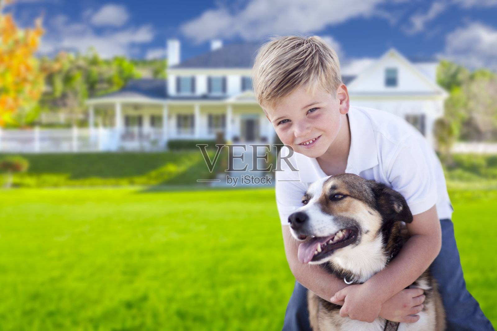小男孩和他的狗在房子前面照片摄影图片