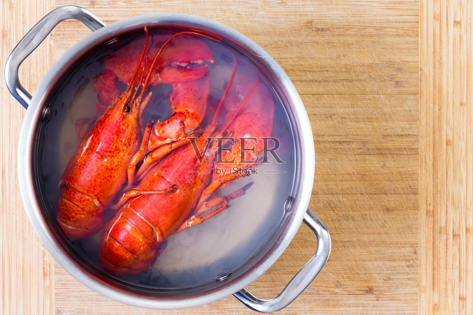 两只红色的龙虾在一锅沸水里照片摄影图片