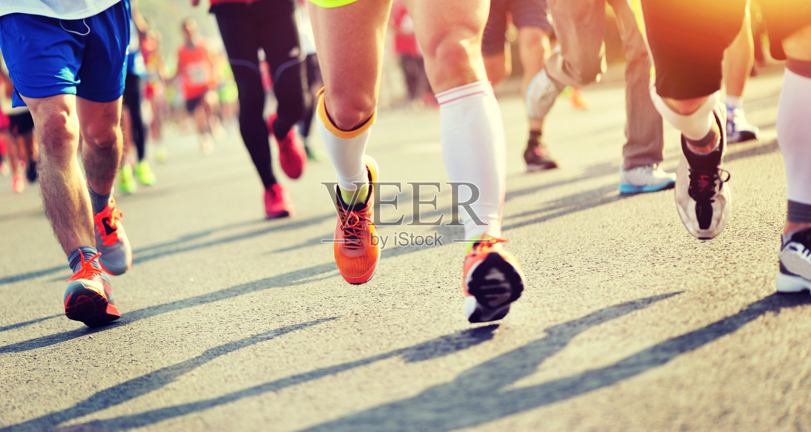 身份不明的马拉松运动员在城市道路上跑步照片摄影图片