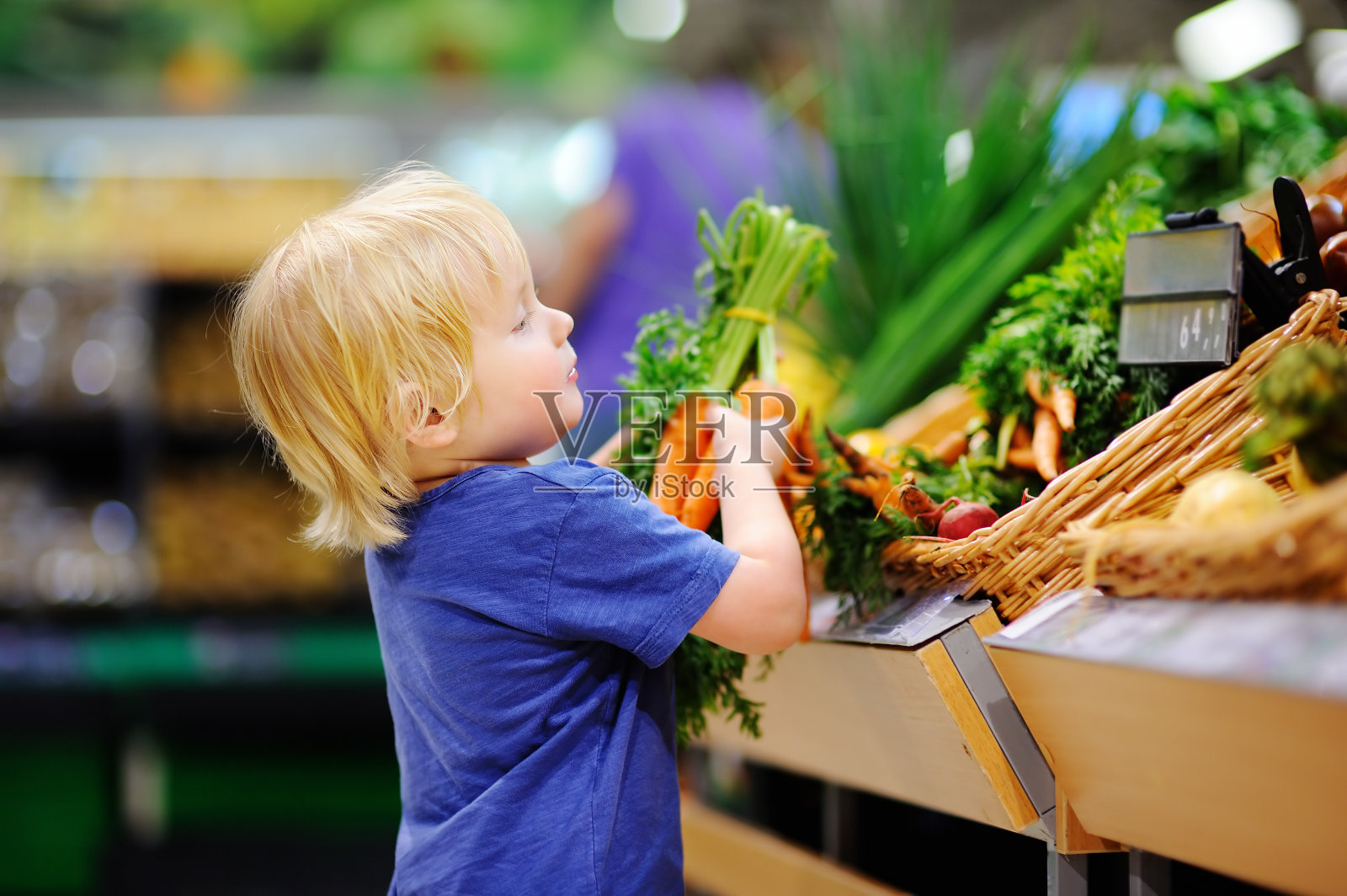 可爱的小男孩在超市选购新鲜的有机胡萝卜照片摄影图片