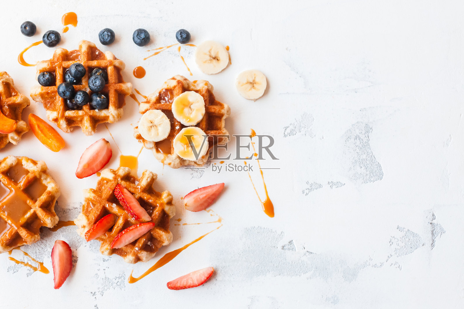 传统的比利时华夫饼配新鲜水果和焦糖。平躺照片摄影图片