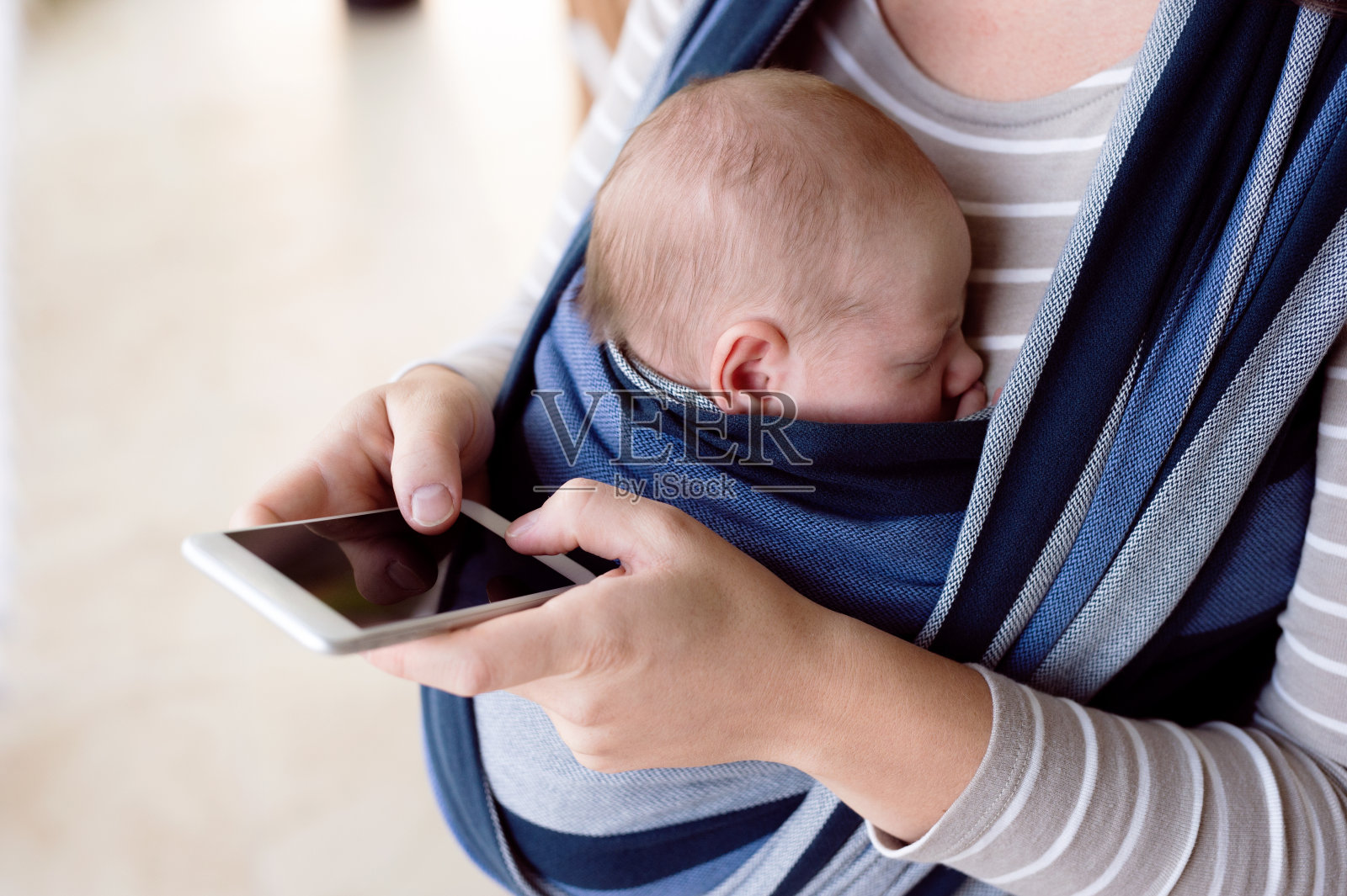 一位面目全非的母亲，带着儿子，手里拿着智能手机照片摄影图片