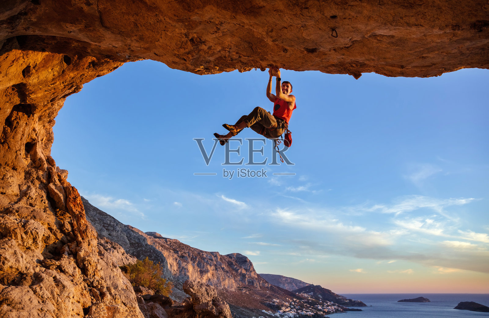 男性攀登者在洞穴中攀爬时抓紧手扶物照片摄影图片