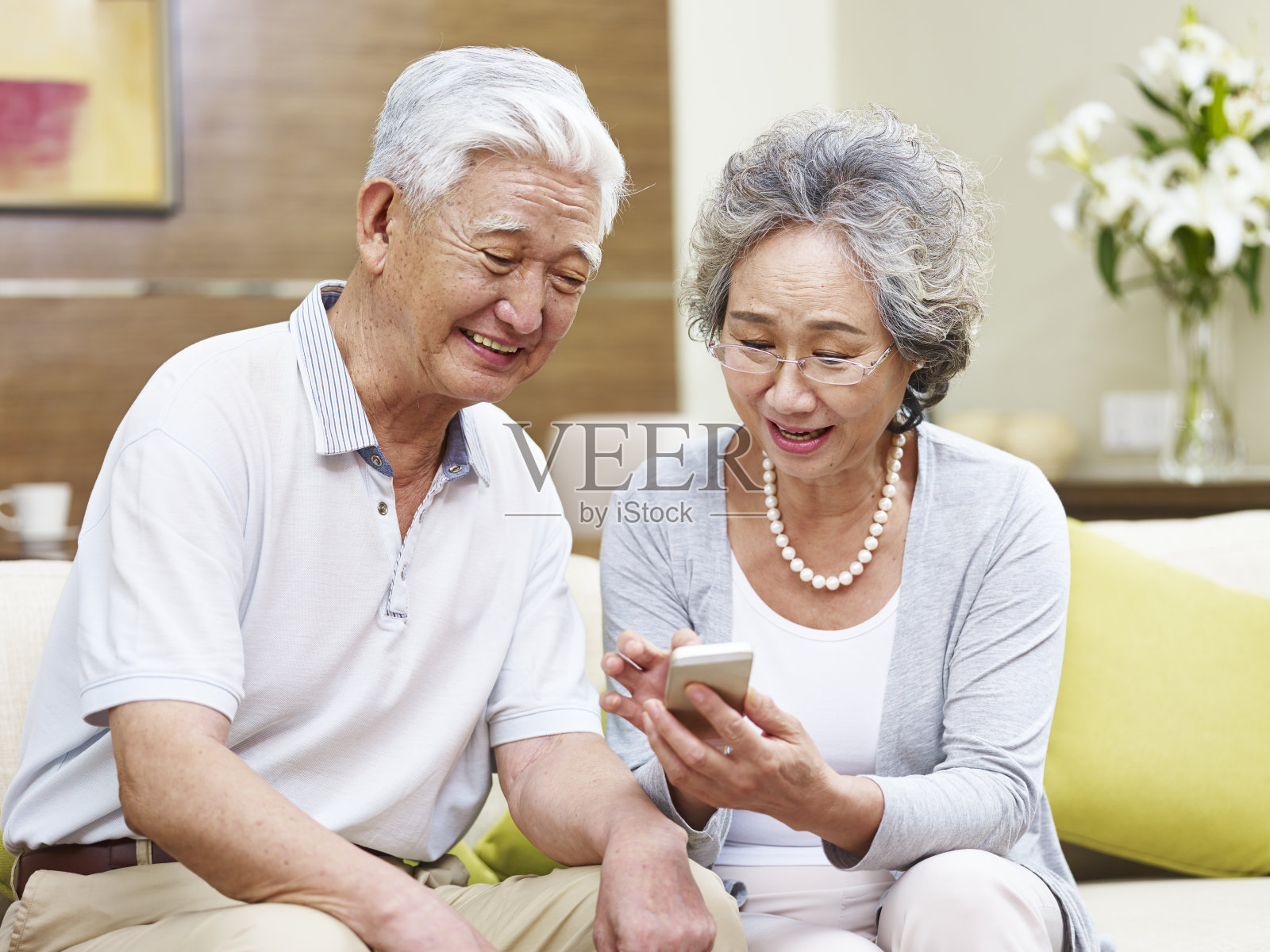 一对在家里使用手机的亚洲老年夫妇照片摄影图片