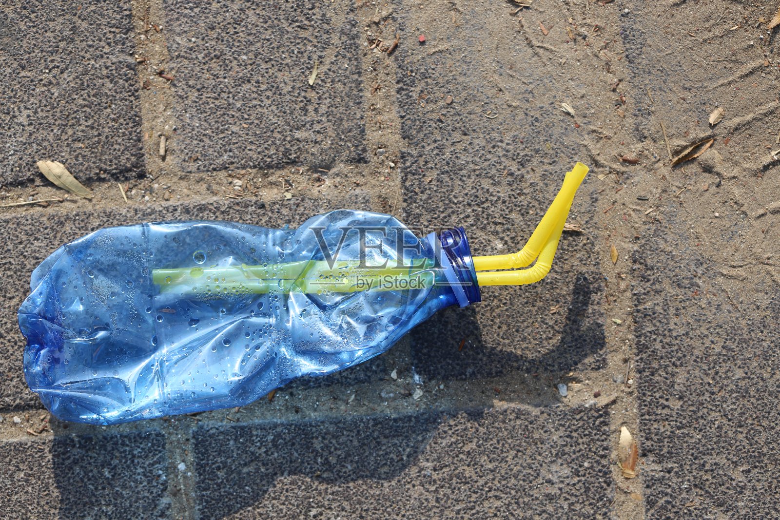 人行道上的碎塑料瓶。照片摄影图片