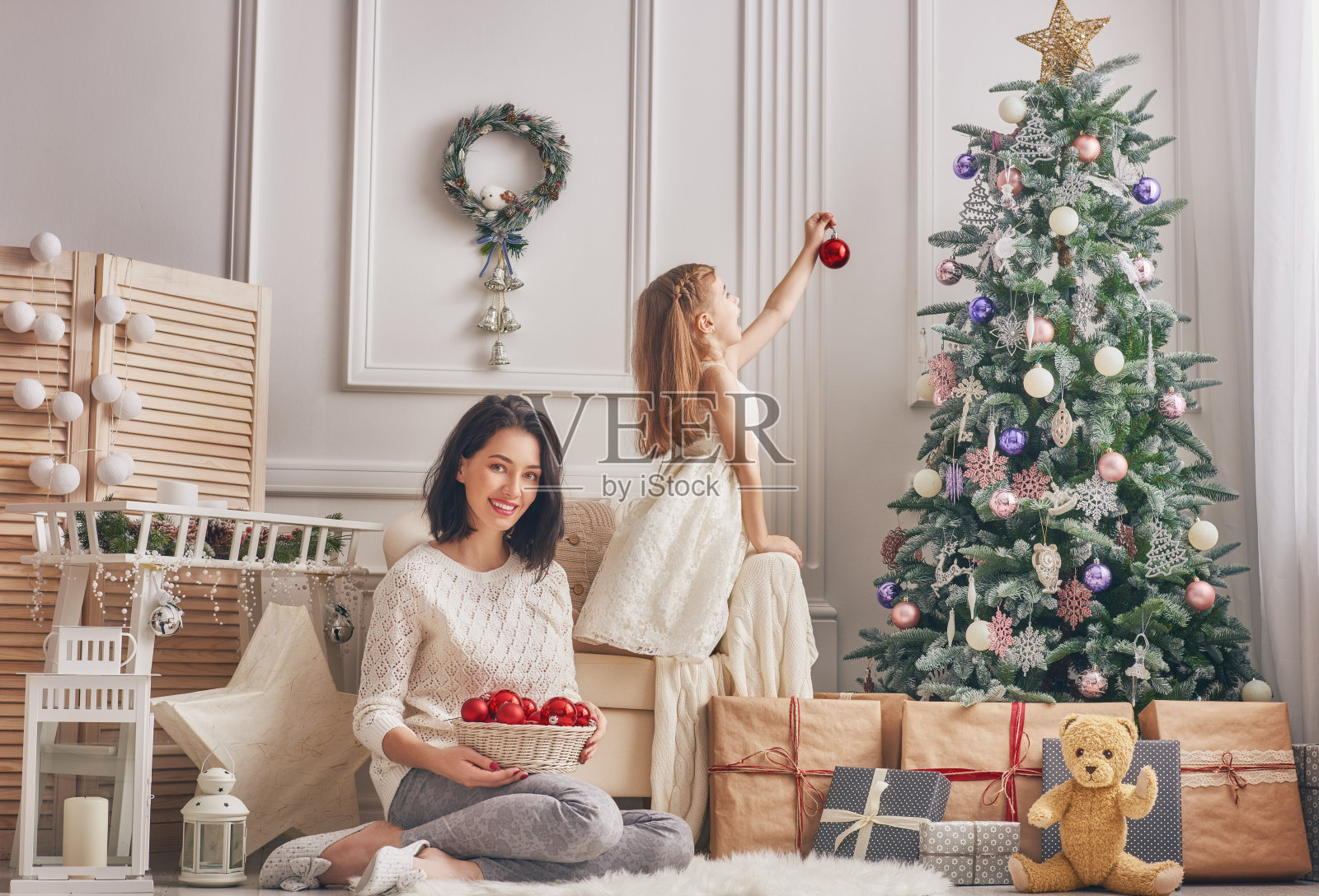 妈妈和女儿装饰圣诞树。照片摄影图片
