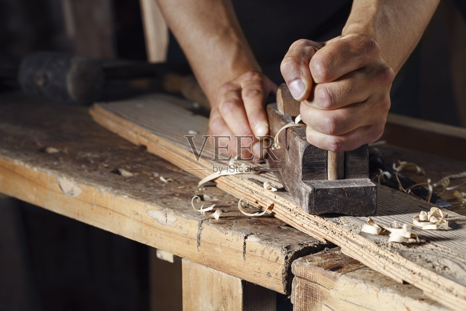 木匠用手刨刨一块木板照片摄影图片