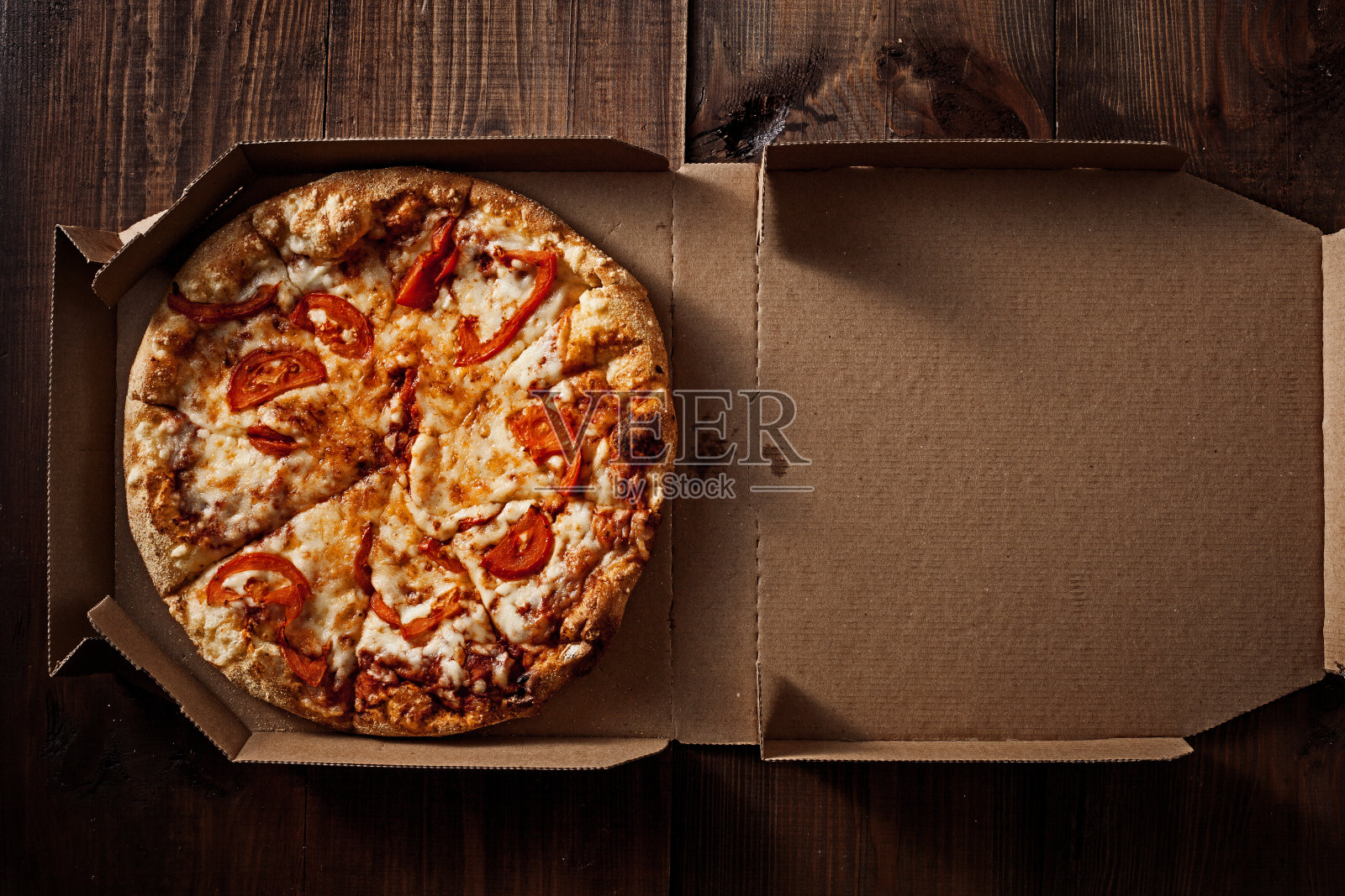 披萨放在外卖箱里，放在木头上照片摄影图片