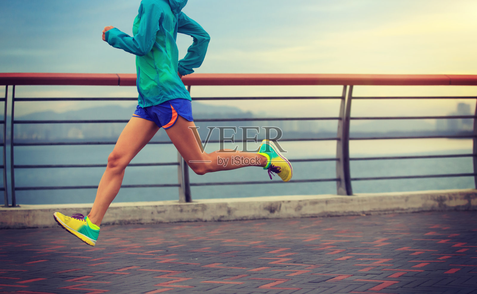 年轻的健身妇女在海边跑步照片摄影图片