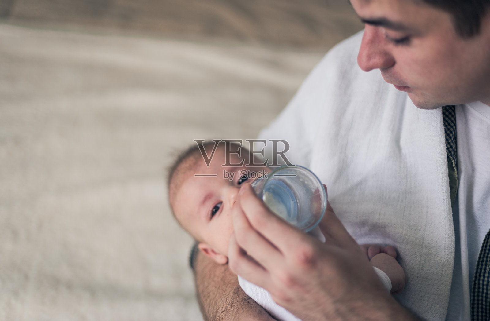一个爸爸给一个漂亮的宝宝喂奶的特写照片摄影图片