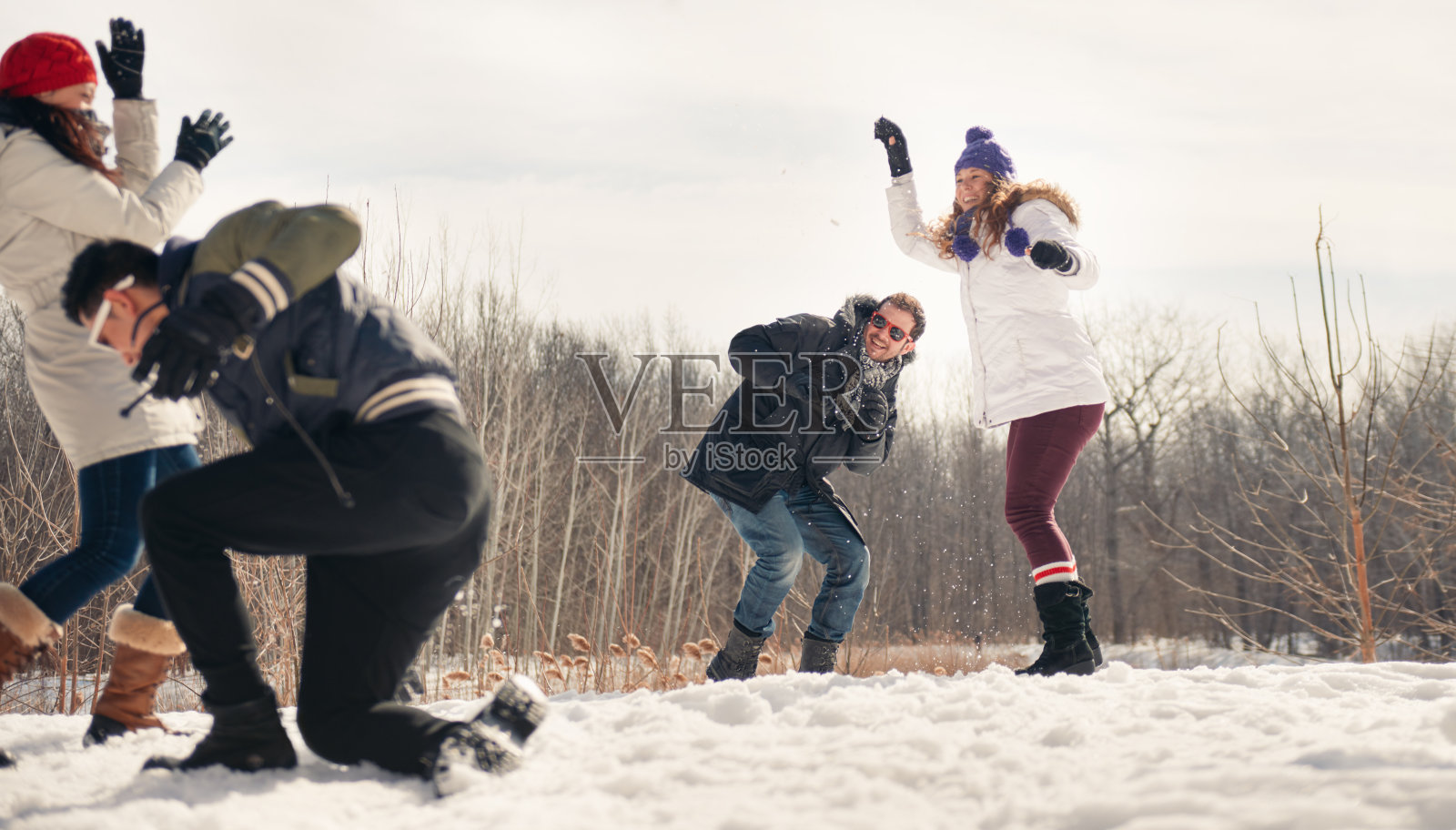 一群朋友在雪地里打雪仗照片摄影图片