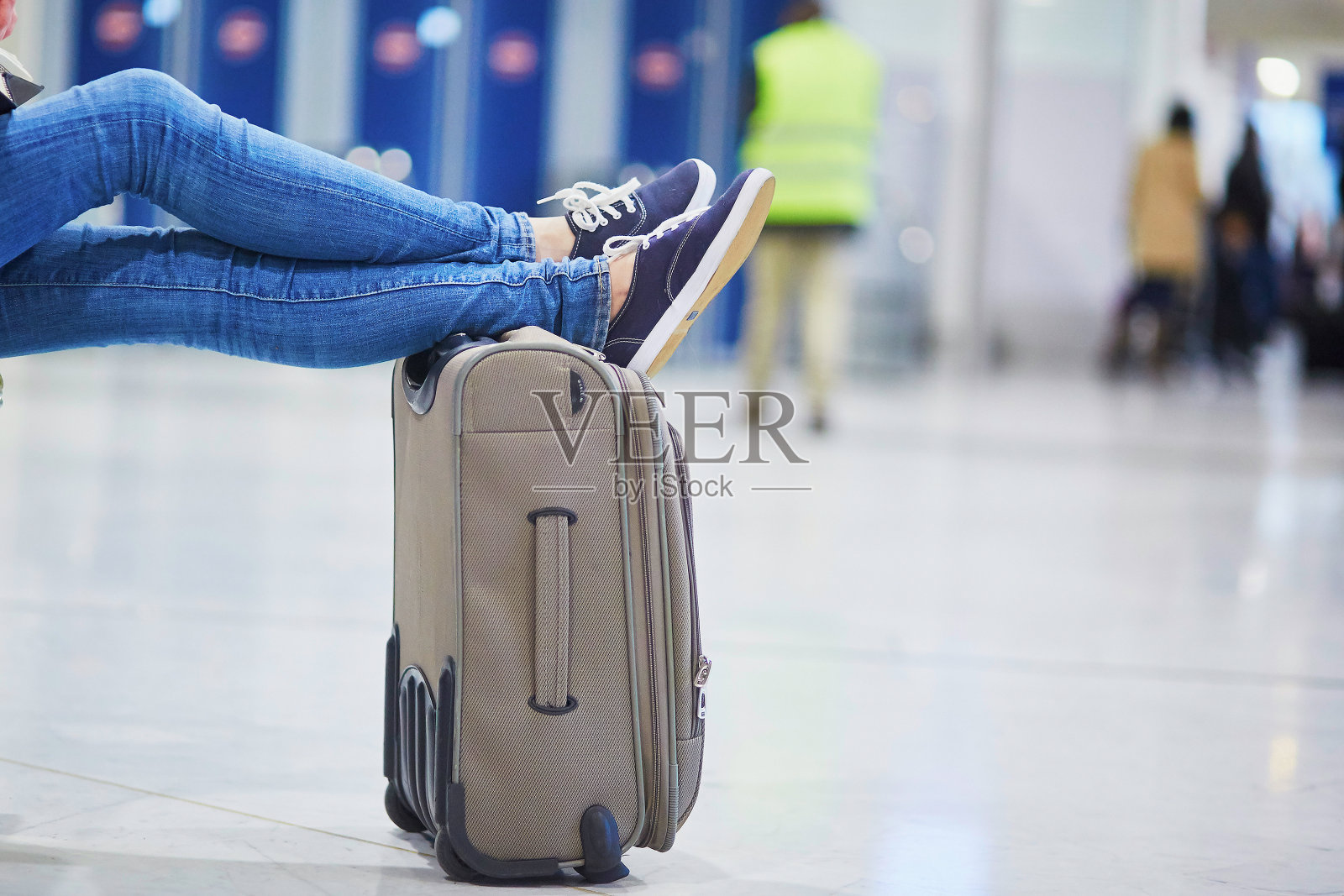 女人的脚在一个手提箱在国际机场的特写照片摄影图片