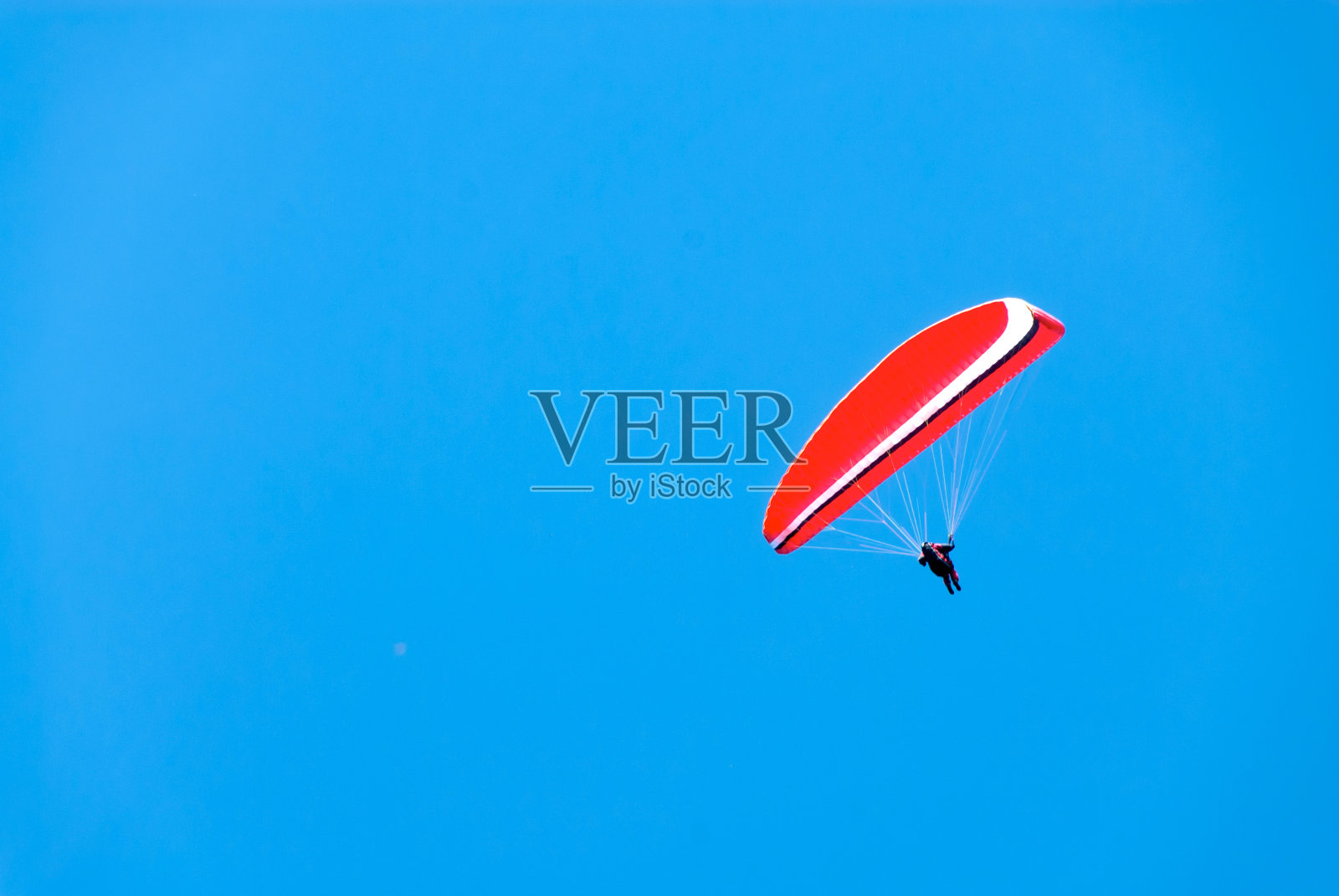 深蓝天空中的红悬滑翔机照片摄影图片