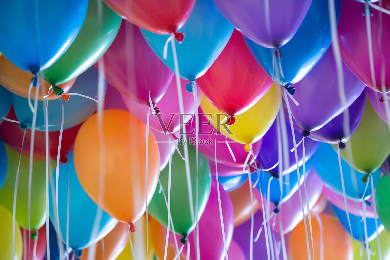 节日里，五颜六色的气球用氦气绑在白色的丝带上照片摄影图片