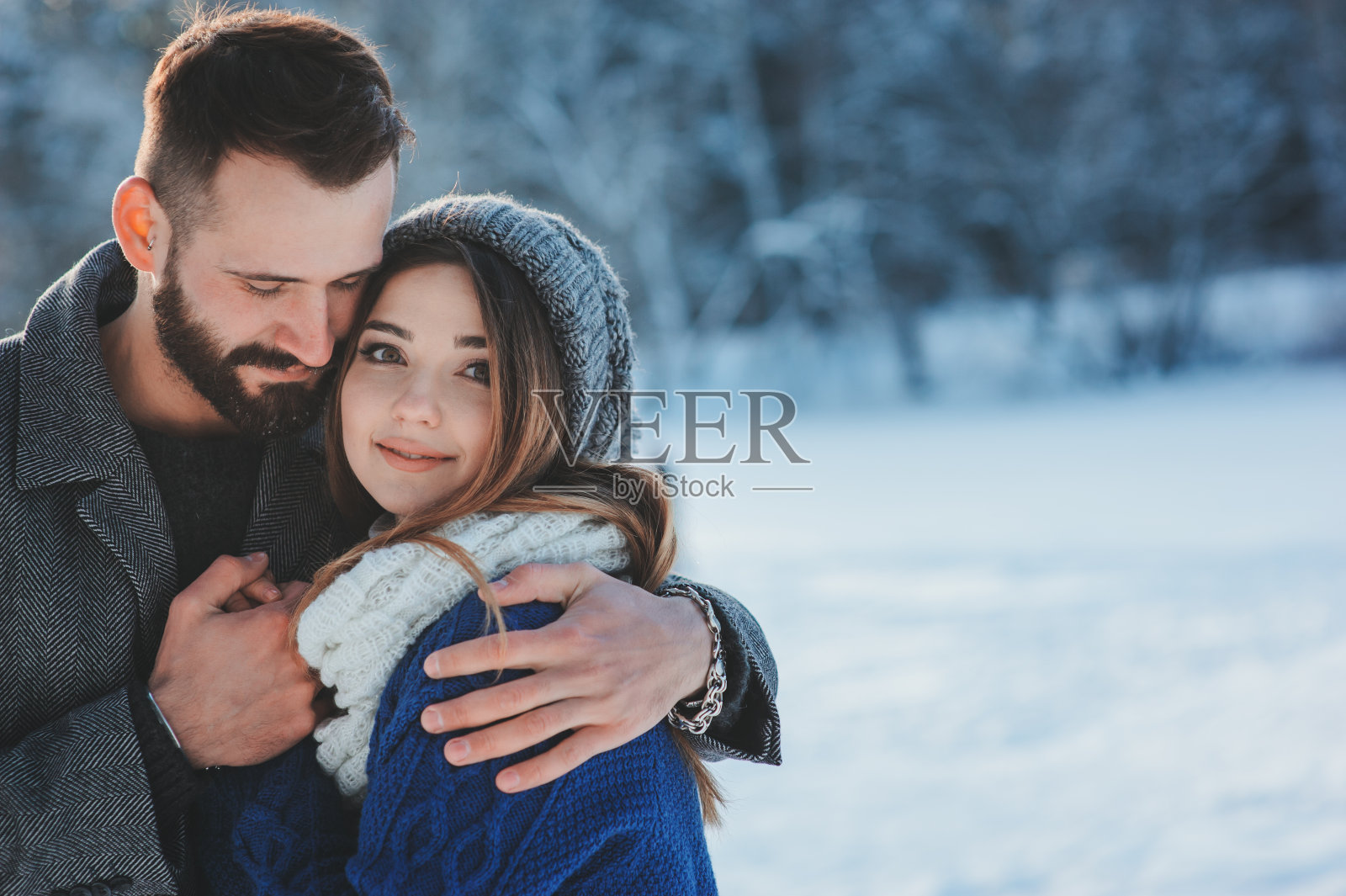 幸福的情侣漫步在白雪覆盖的冬日森林里照片摄影图片