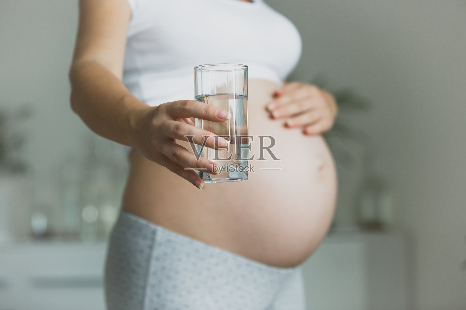 孕妇拿着一杯水的特写照片摄影图片